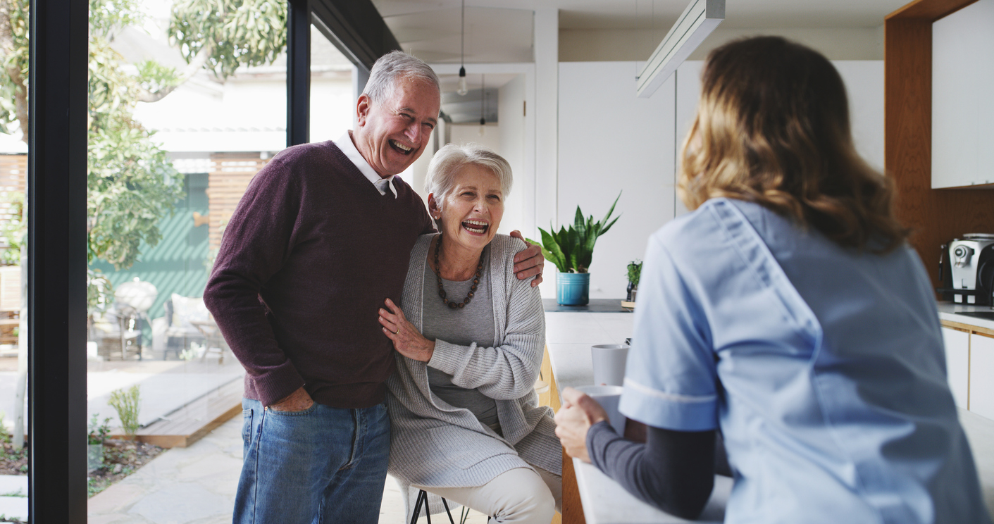 Couple, nurse and assisted living with a senior man, woman and caregiver laughing in a retirement home kitchen. Medical, healthcare and fun with an elderly male, female and carer joking in a house