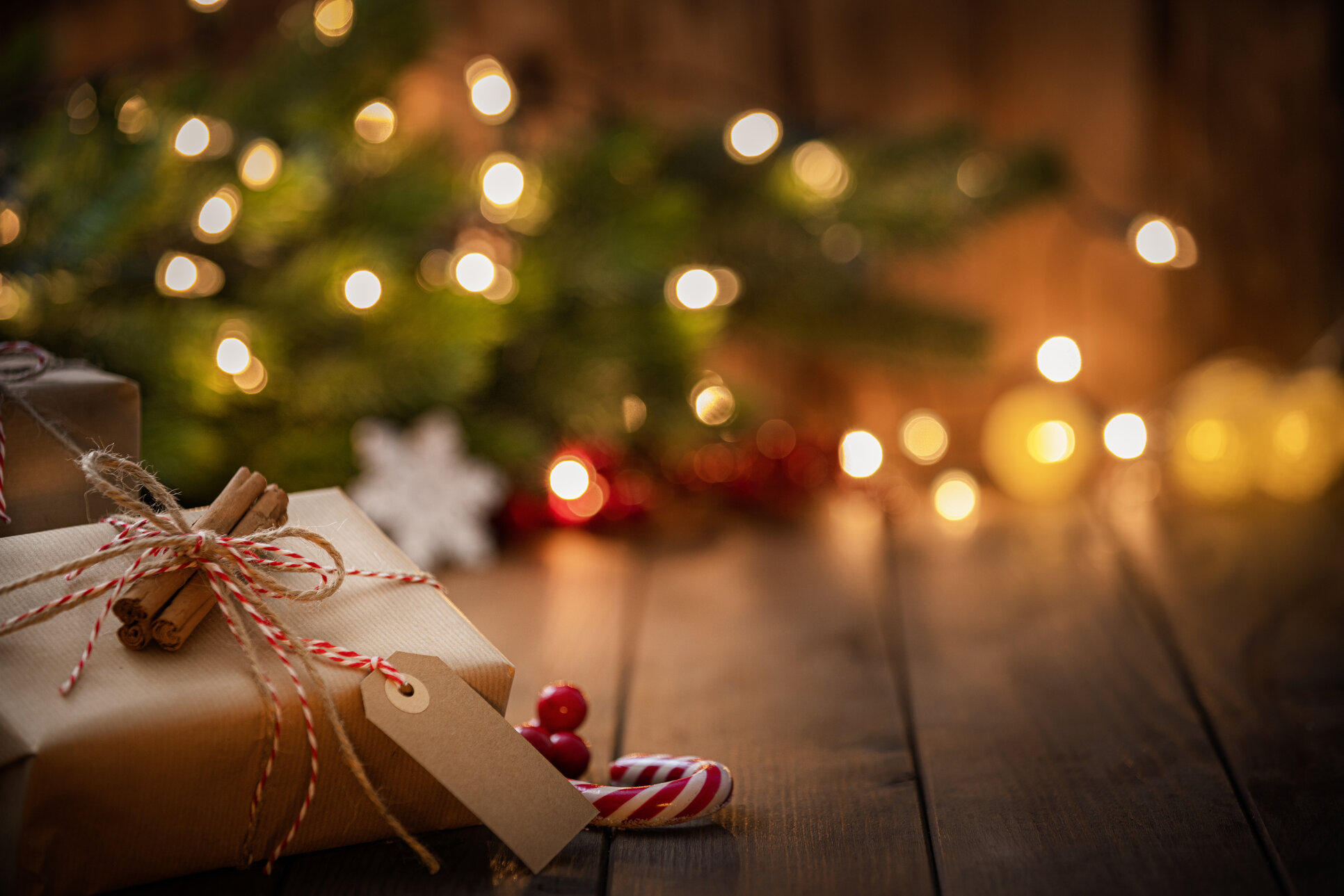 Brown Christmas gift box with a blank tag on rustic wooden table. High resolution 42Mp studio digital capture taken with Sony A7rII and Canon EF 70-200mm f/2.8L IS II USM Telephoto Zoom Lens